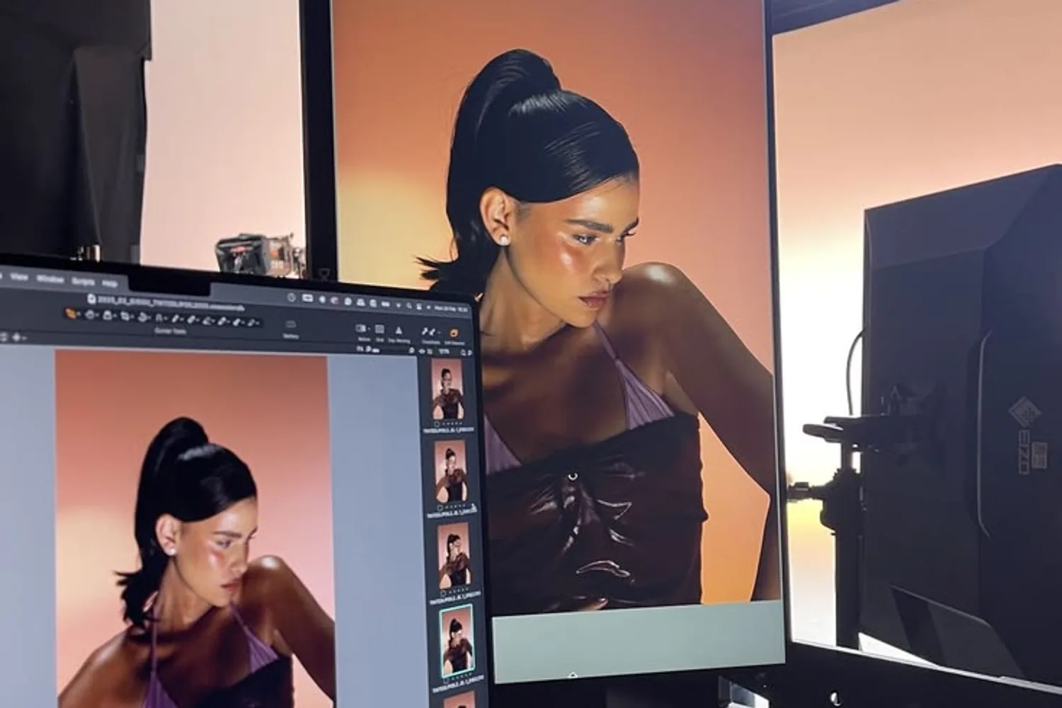Retouching a photograph on a monitor and a laptop on set